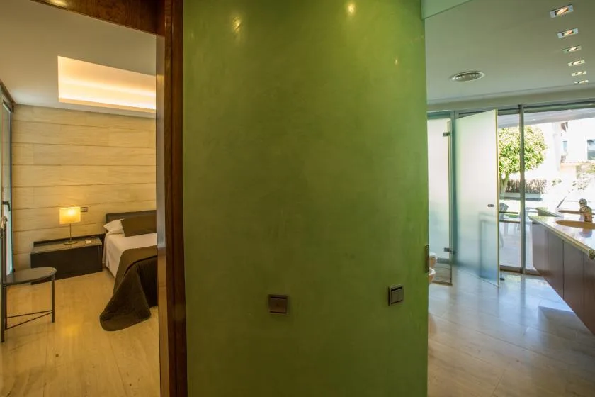 Se ve un dormitorio y una zona de baño contigua a través de una puerta abierta.