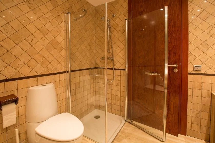 Un baño con azulejos, inodoro y ducha de vidrio.