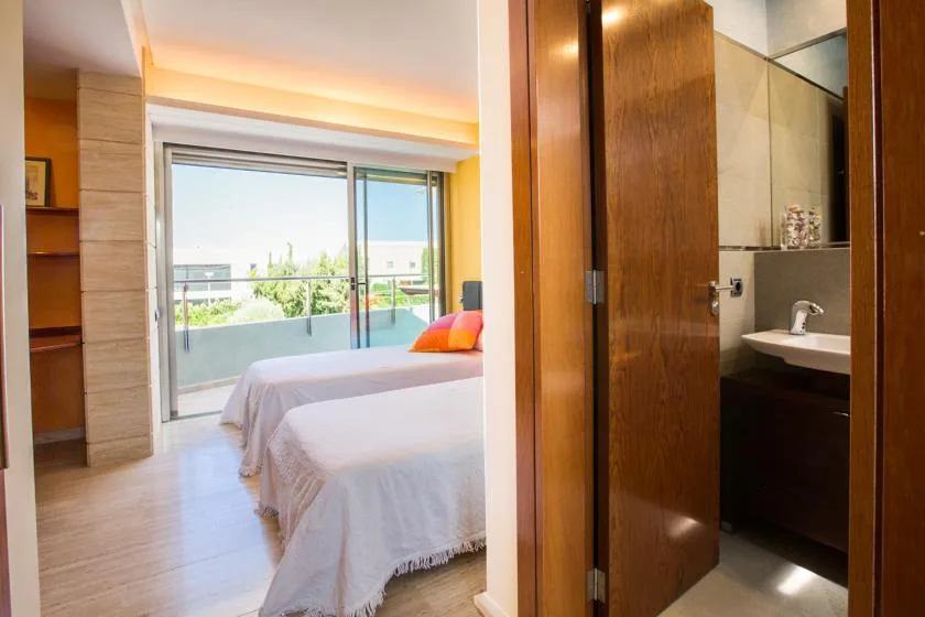 Un dormitorio con una cama junto a puertas corredizas de vidrio que dan a un balcón.