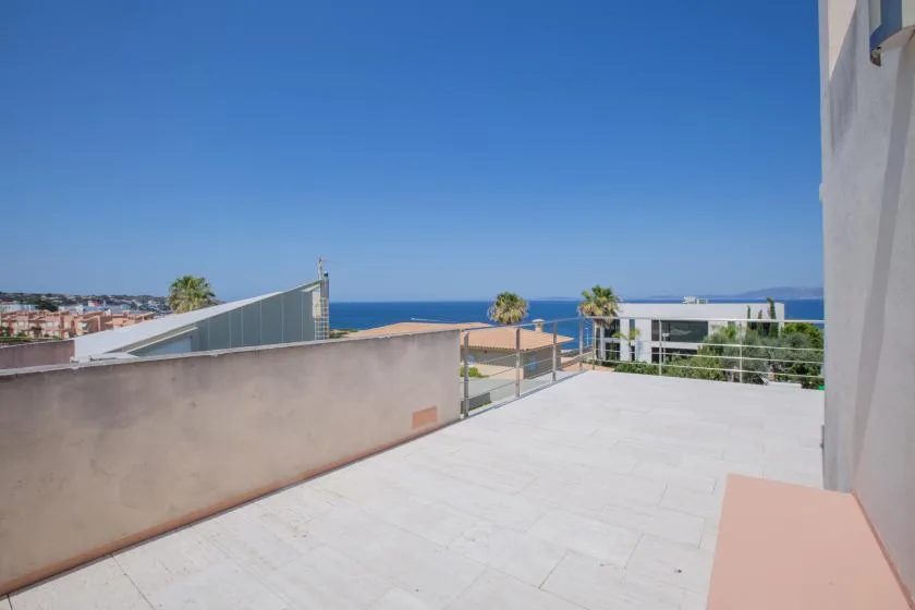 Una terraza en la azotea da al mar y a edificios cercanos.