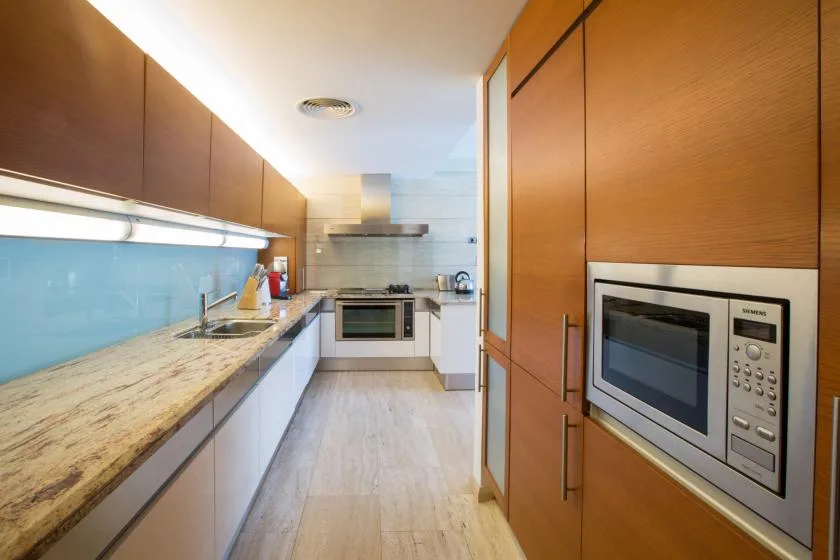 Una cocina moderna con una encimera larga y electrodomésticos integrados.