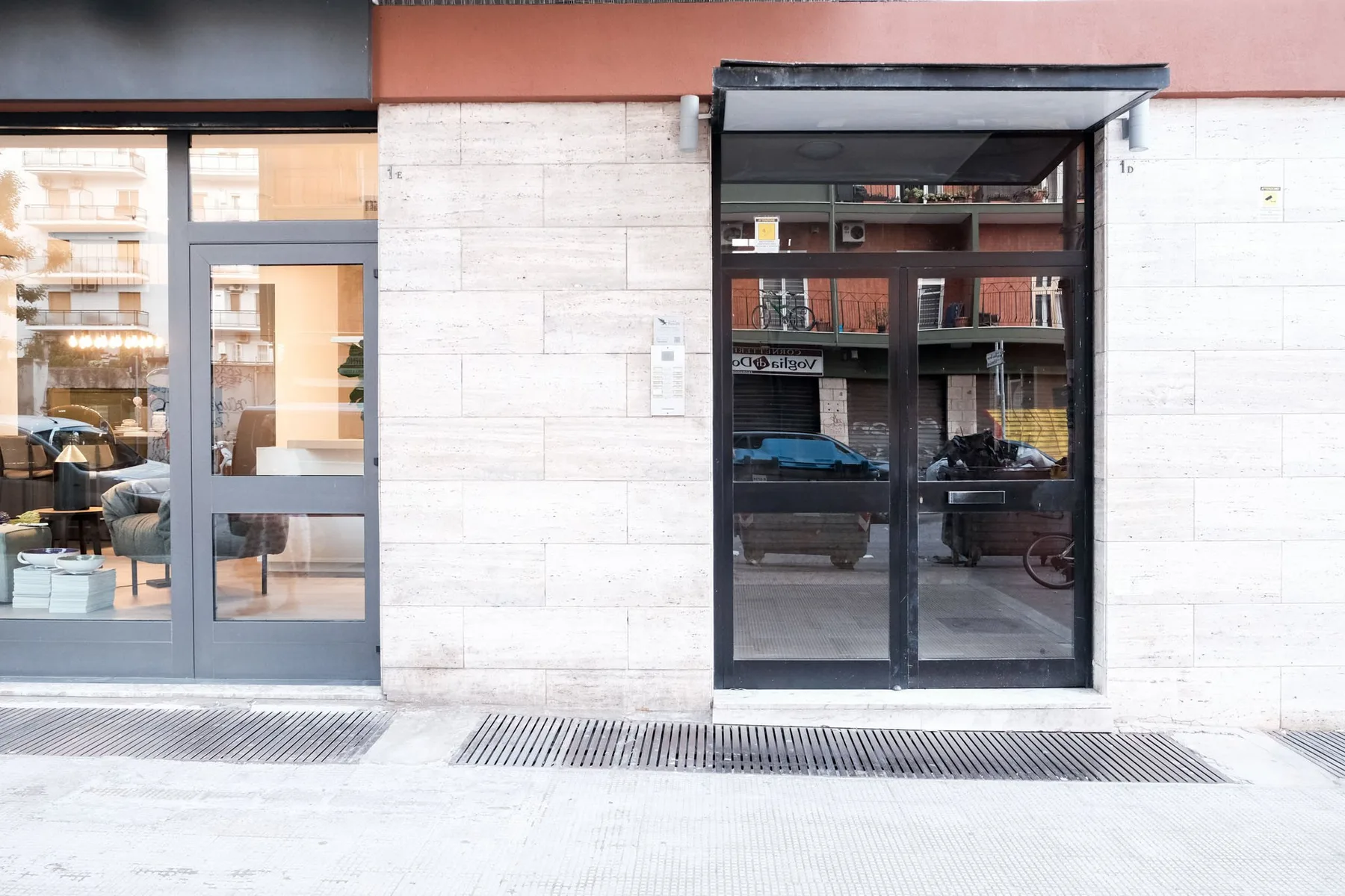 A building entrance with glass doors and a broad white stone facade.