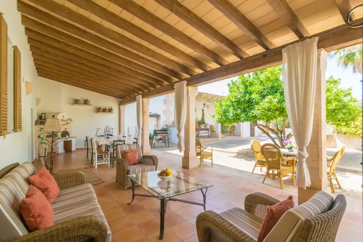 Una zona de estar cubierta con mesa de comedor da a un patio soleado.