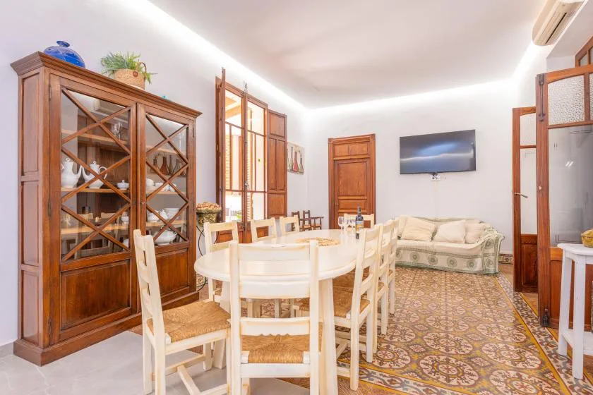 Comedor con una vitrina de madera y una zona de estar al fondo.