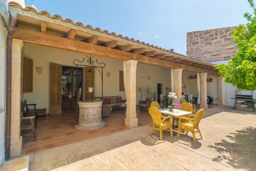 Un patio exterior cubierto con asientos y una mesa de comedor.