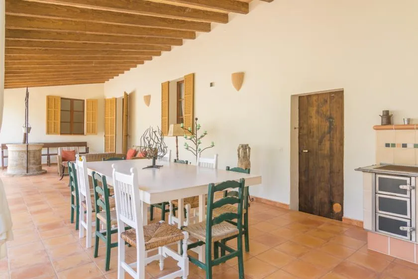 Comedor con una mesa larga y sillas bajo vigas de madera expuestas.