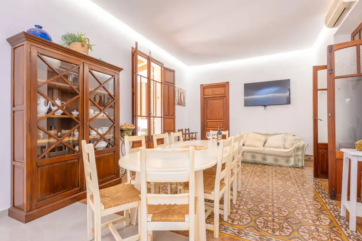 Comedor con una mesa grande y una vitrina de madera.