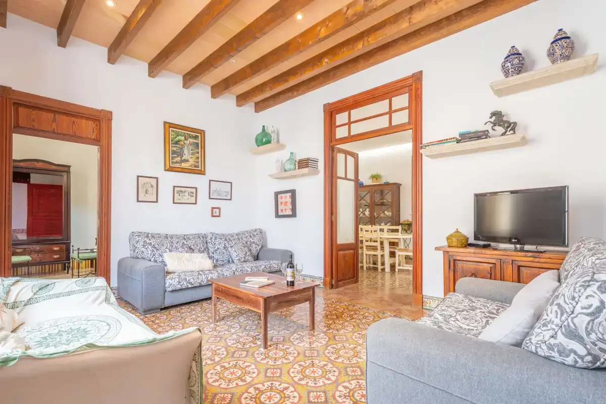 Una sala de estar con asientos, una mesa de centro y un televisor.
