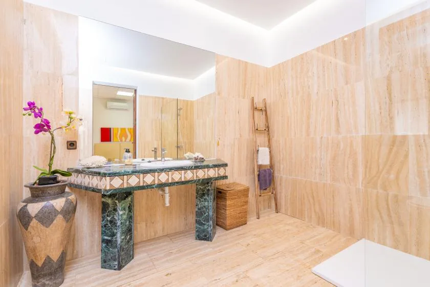 Un baño con un lavabo alicatado y una bañera blanca.