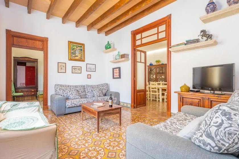 Una sala de estar con asientos, una mesa de centro y un televisor.
