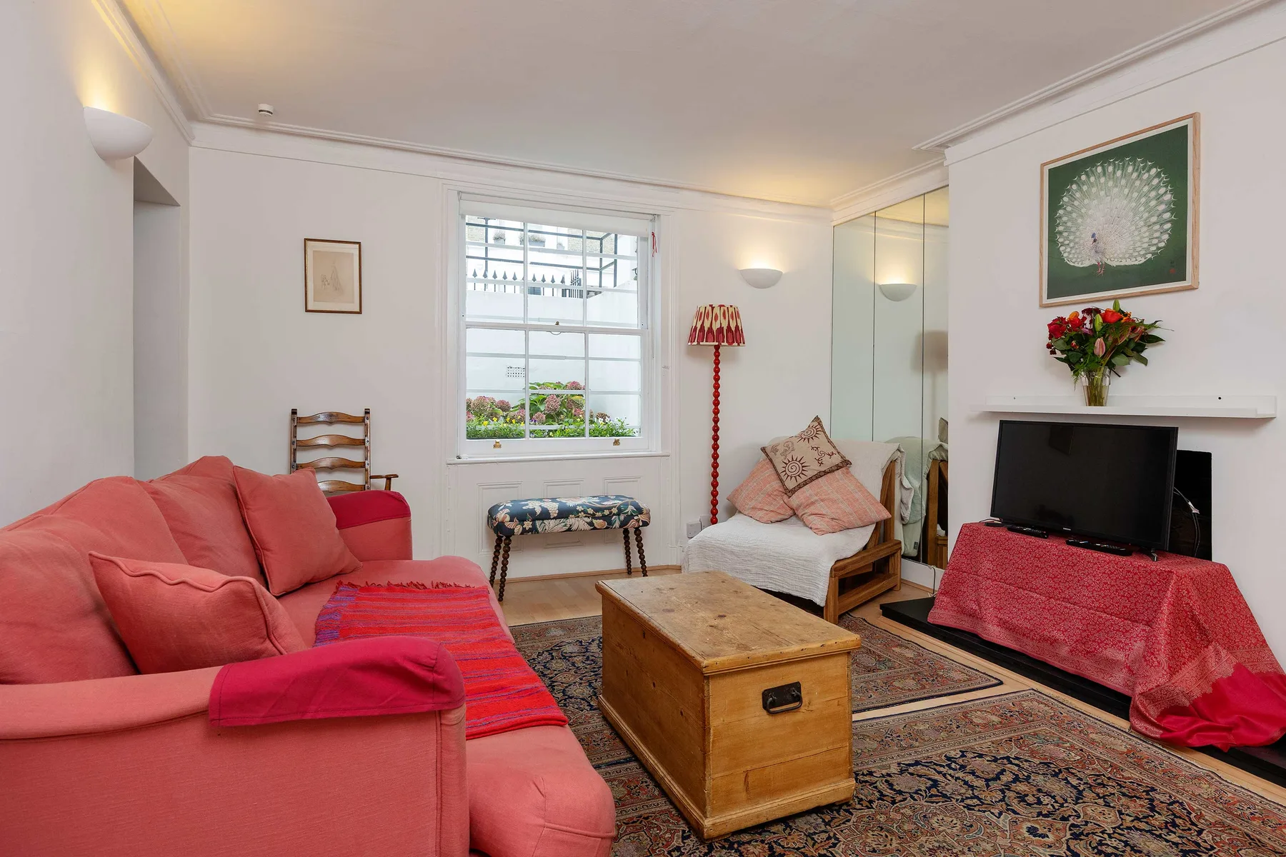 A living room with seating, a wooden coffee table, and a television.