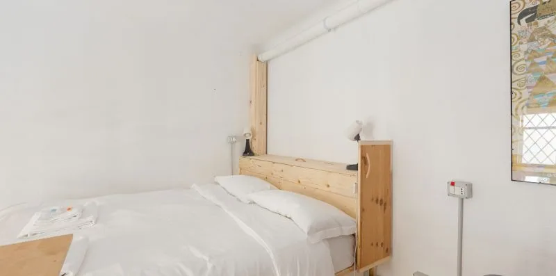 Un dormitorio con una cama y un cabecero de madera.