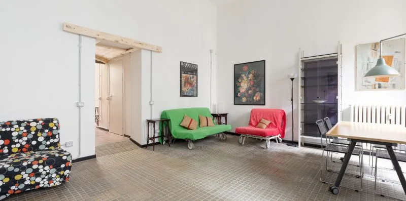 Una sala luminosa con asientos coloridos y una mesa.