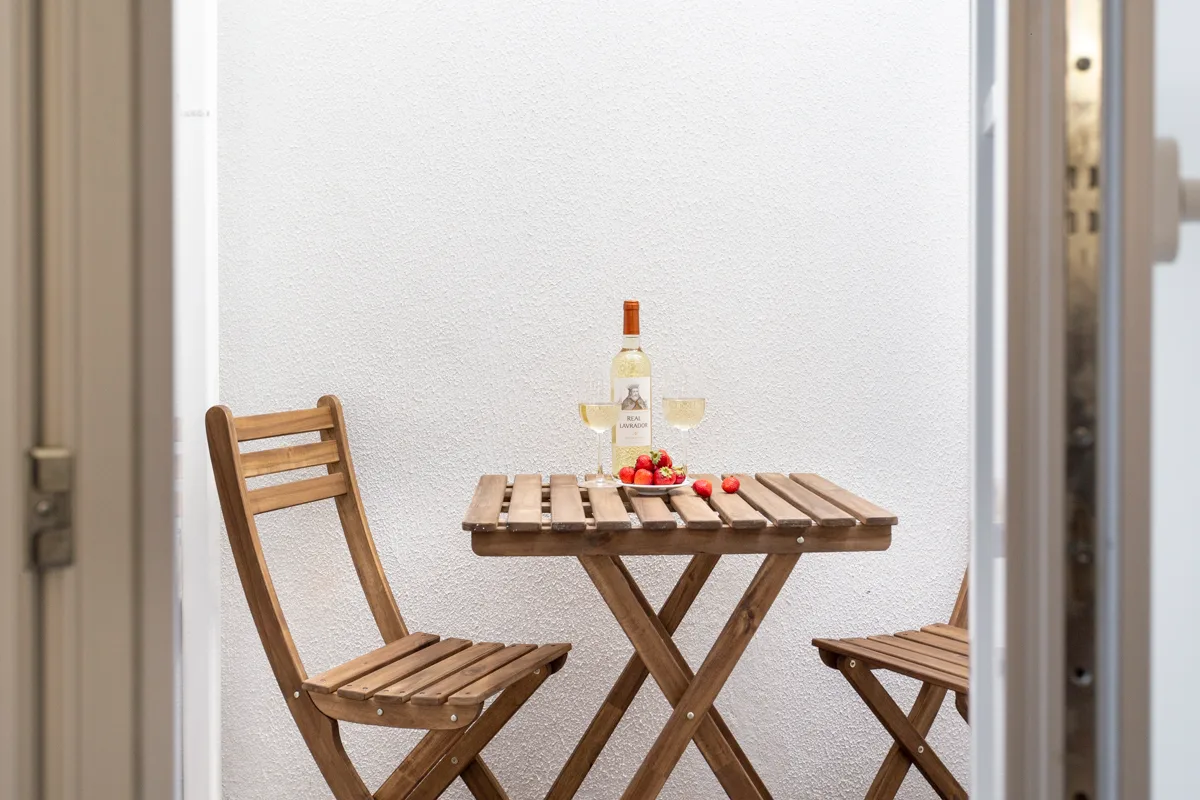A small outdoor seating area with a wooden table and chairs.