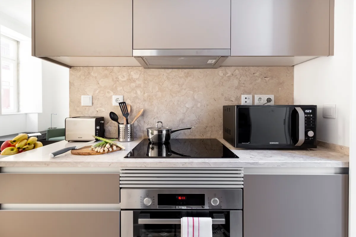 A modern kitchen with a stovetop, oven, and microwave.