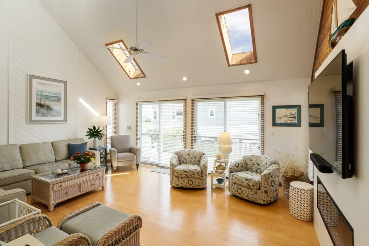 Una sala de estar luminosa con asientos, ventanas grandes y tragaluces.
