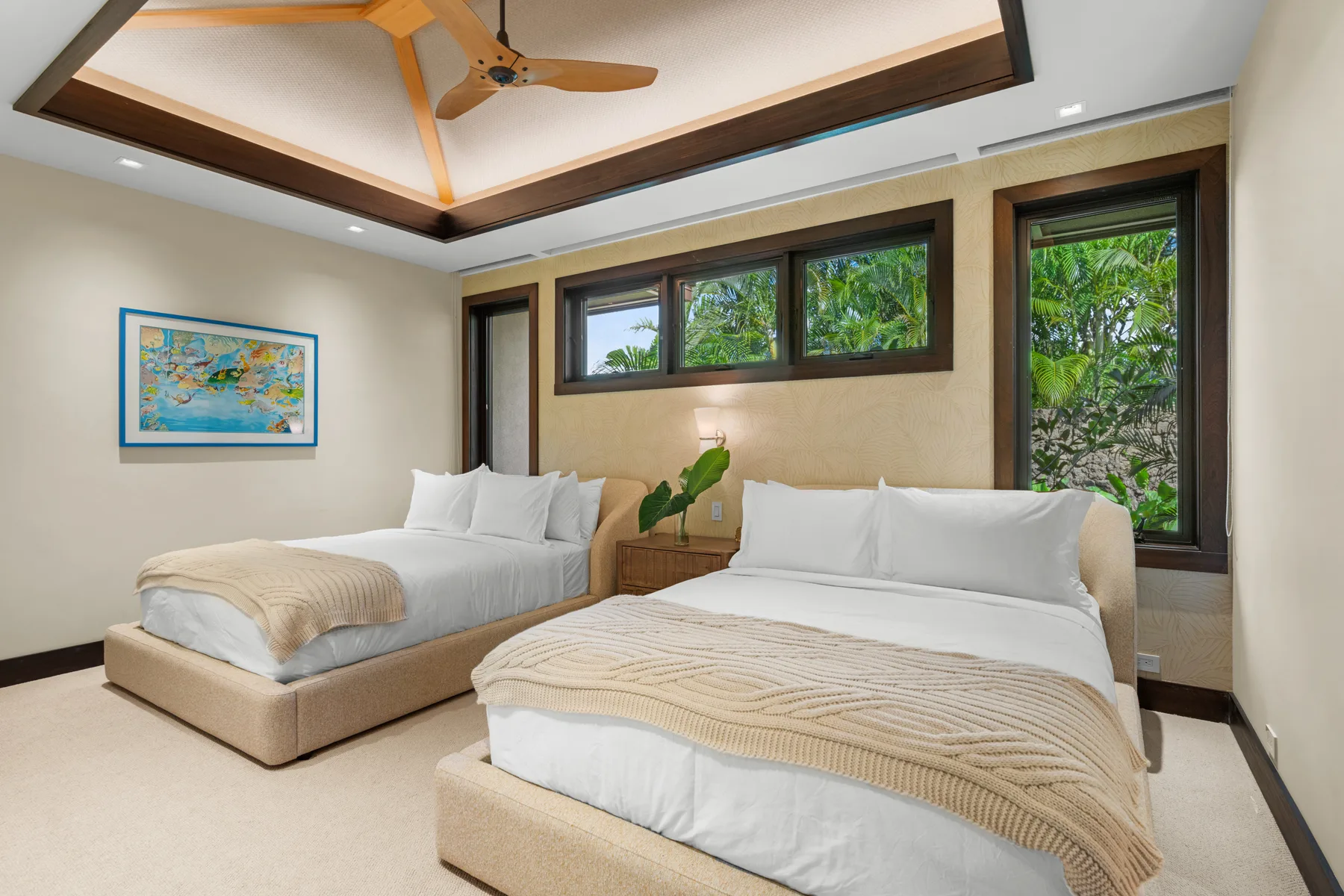 Un dormitorio con dos camas, ropa de cama clara y ventanas con vistas a la vegetación.