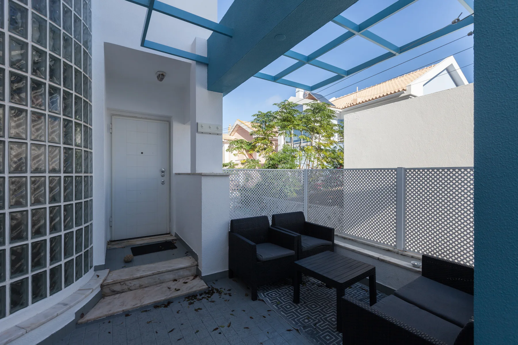 A covered outdoor seating area with a table and a translucent roof.