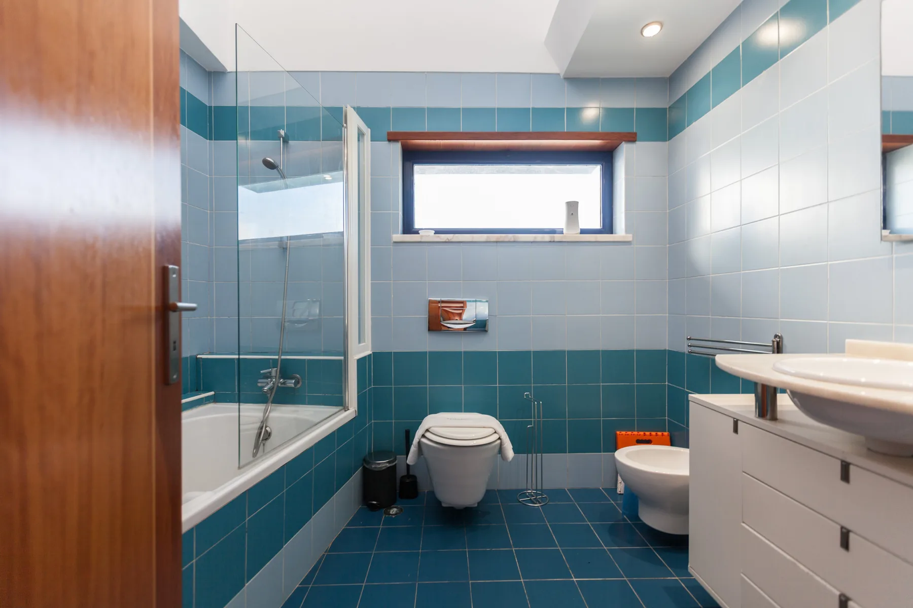 A tiled bathroom with a shower, toilet, and sink.