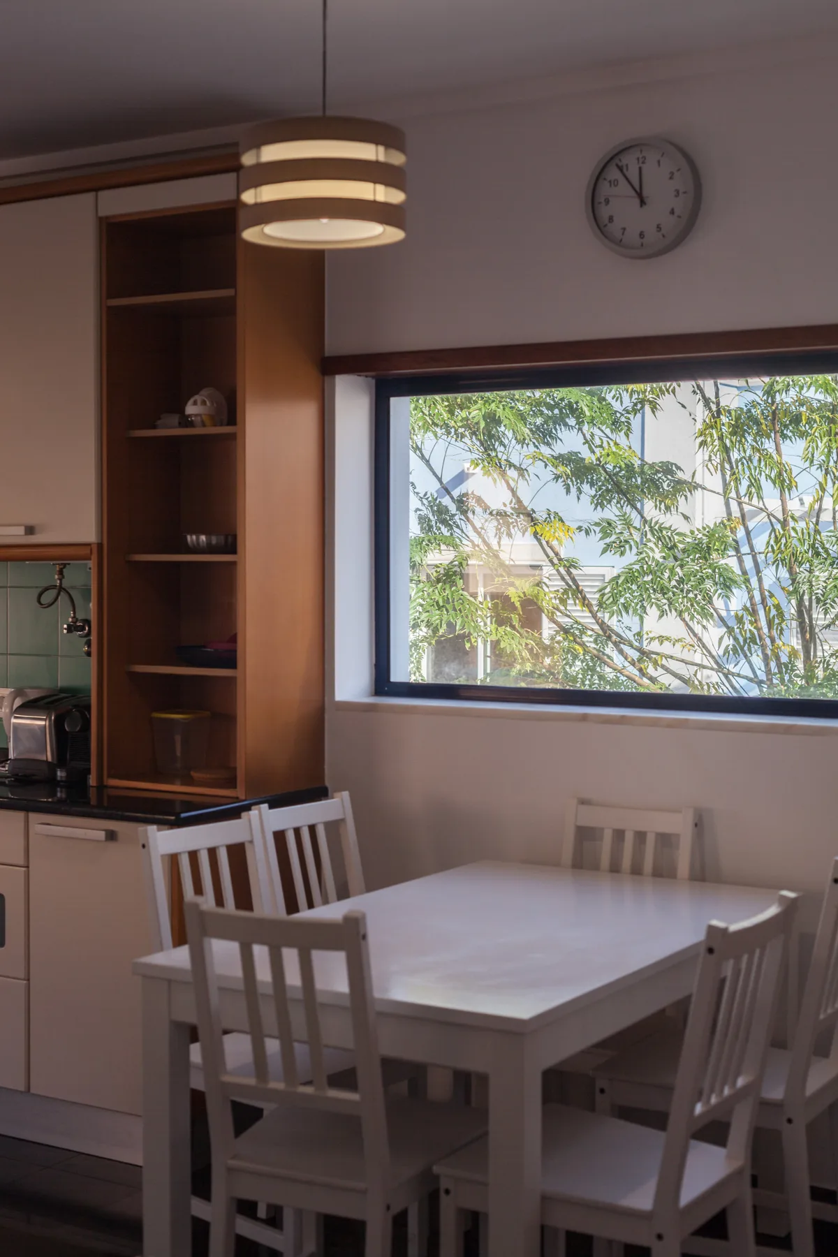 A dining area with a white table beside a large window.
