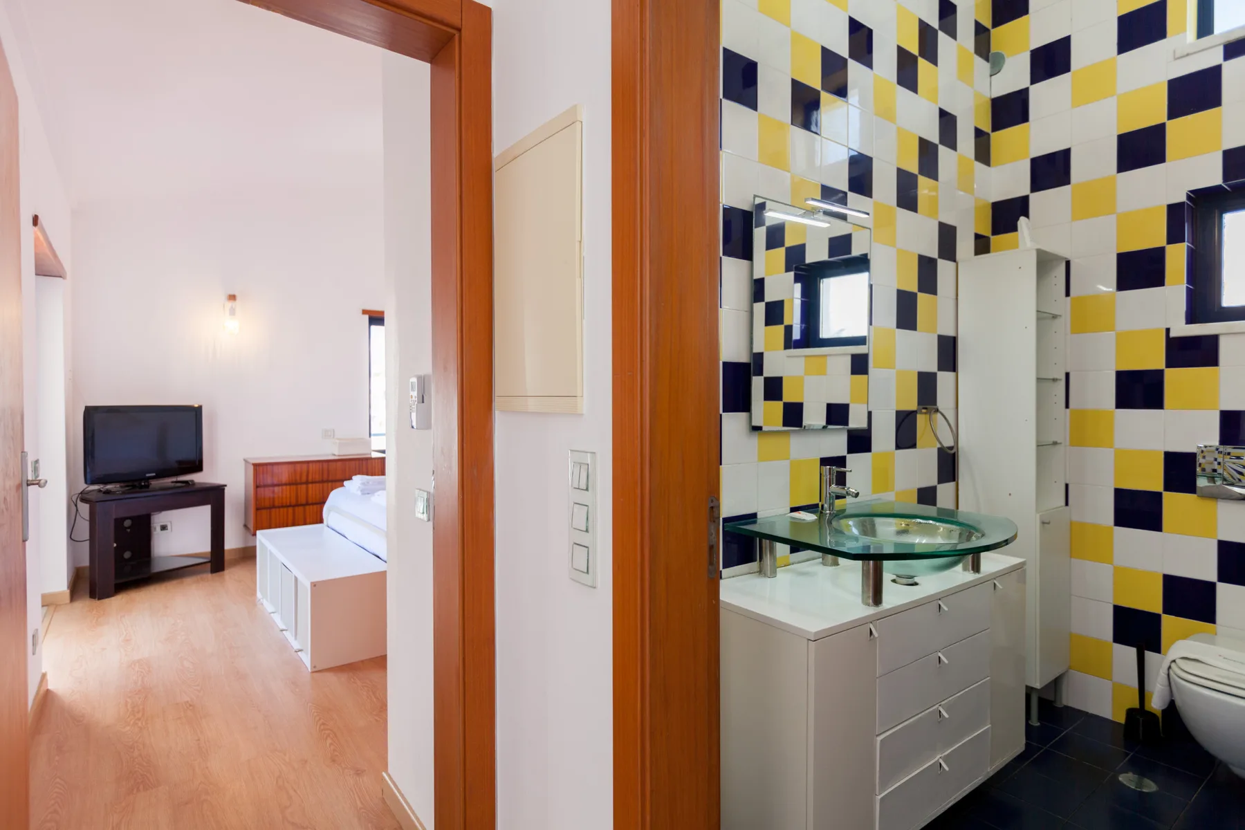 A bedroom and adjoining bathroom are visible through an open doorway.