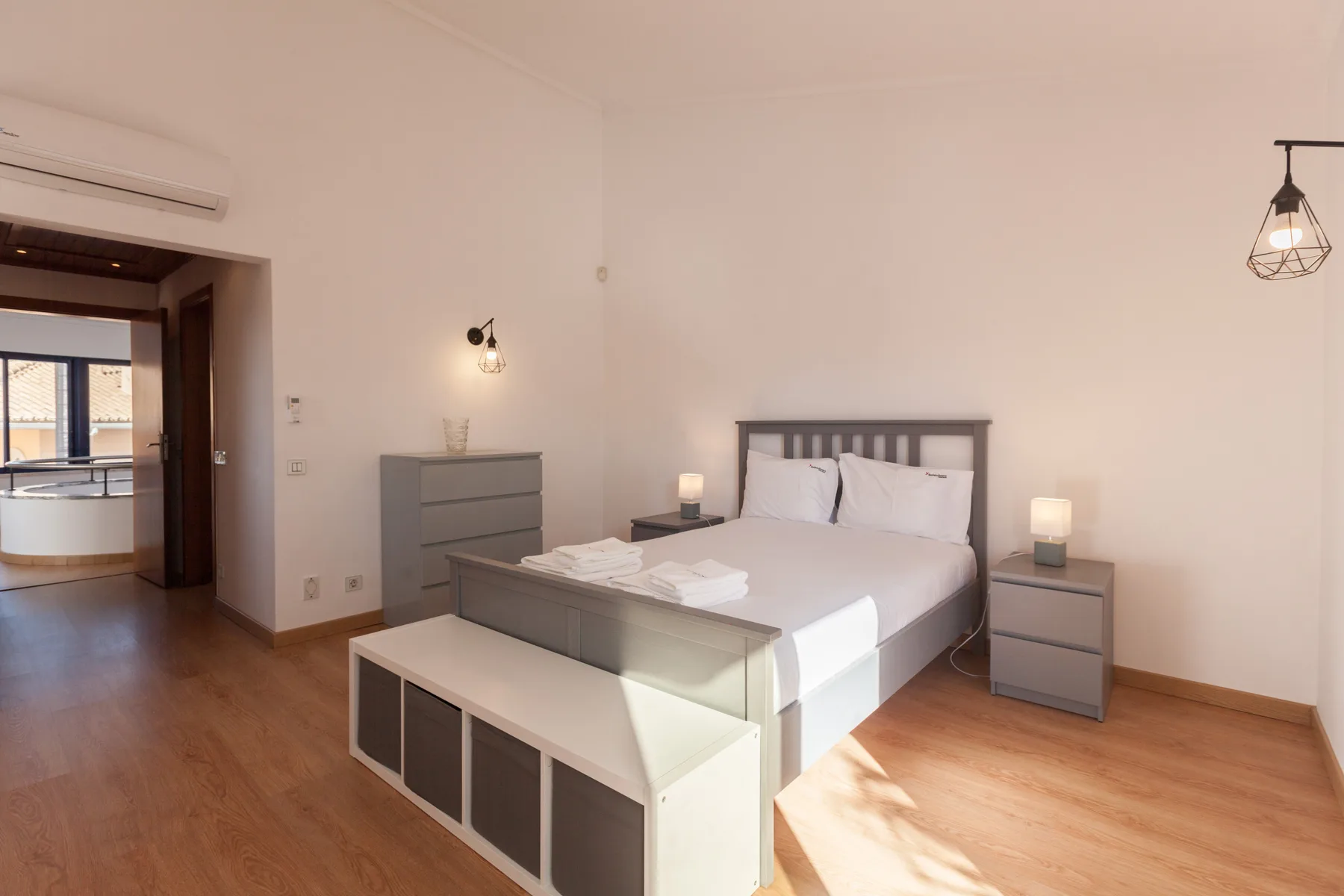 A bedroom with a double bed, bedside tables, and a dresser.