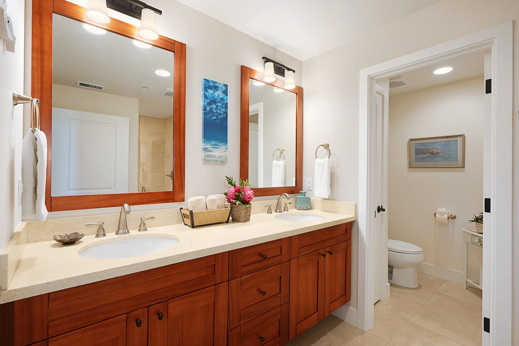 A bathroom vanity with a long counter and a doorway to the toilet area.