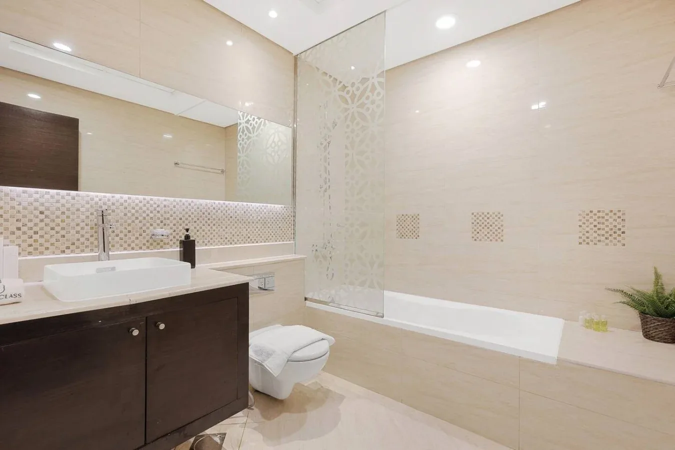 Un baño luminoso con lavabo, inodoro y bañera.
