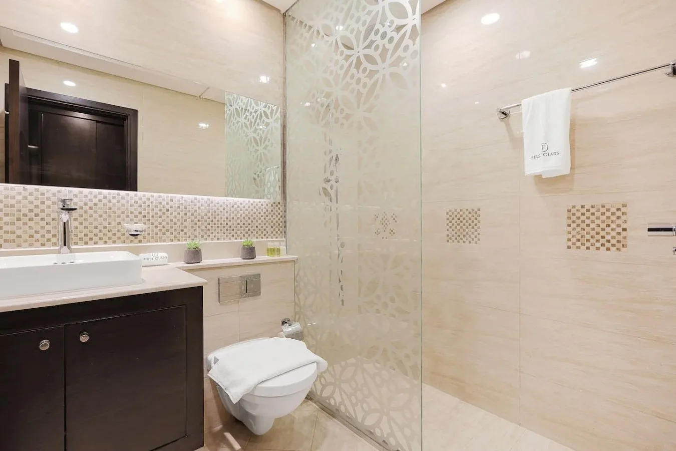 Un baño de azulejos con lavabo, inodoro y zona de ducha.