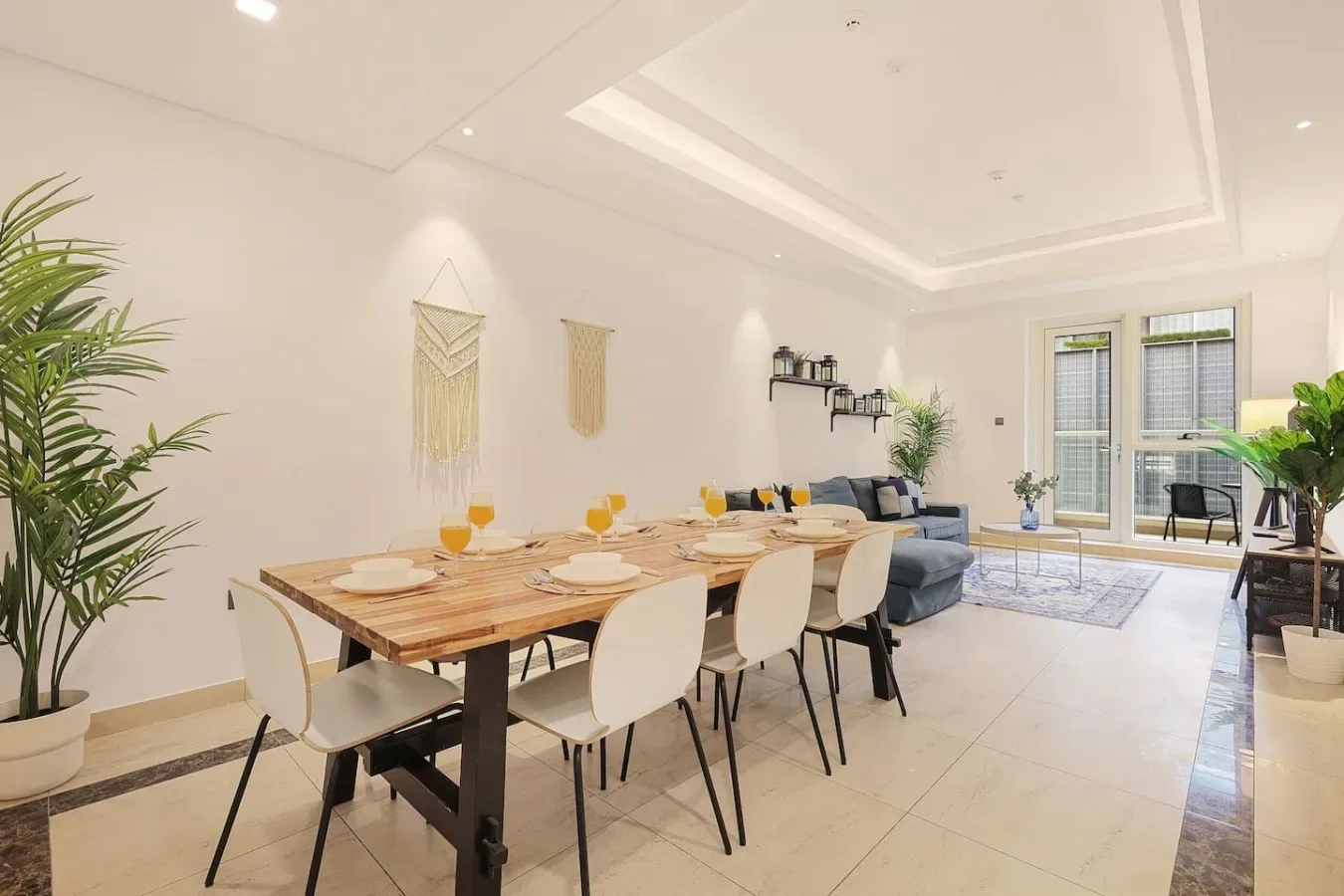 A bright open-plan dining and living area with a long table and seating.