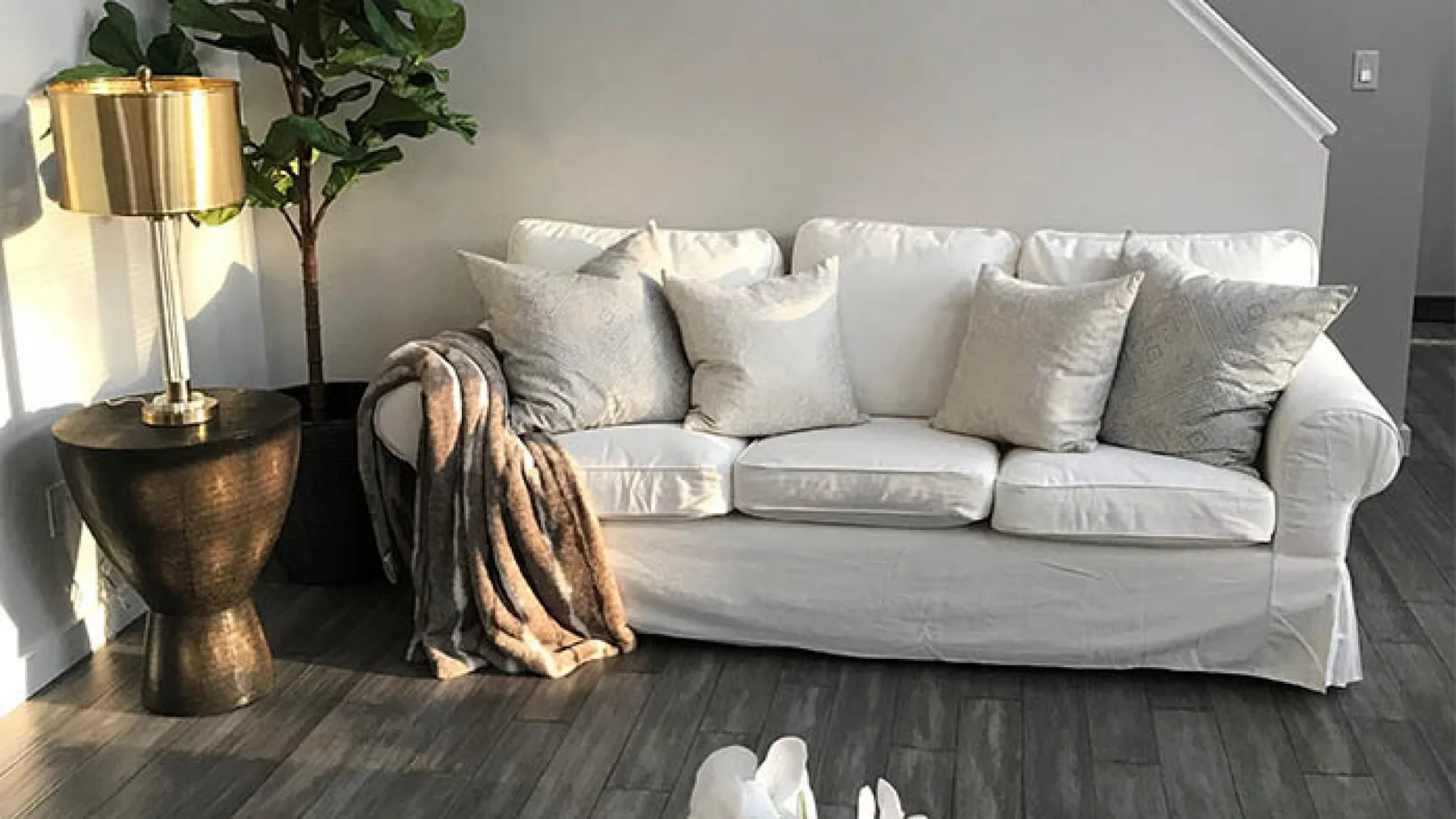 A living room with a light-colored sofa and a floor lamp.