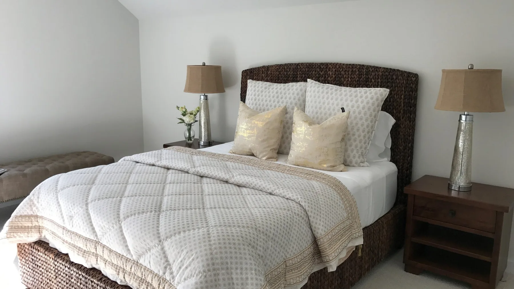 A bedroom with a neatly made bed and matching bedside lamps.