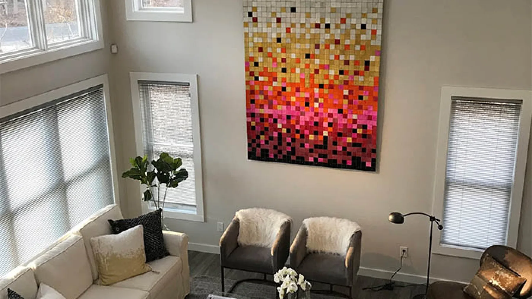 Una sala luminosa con asientos, ventanas altas y arte colorido en la pared.