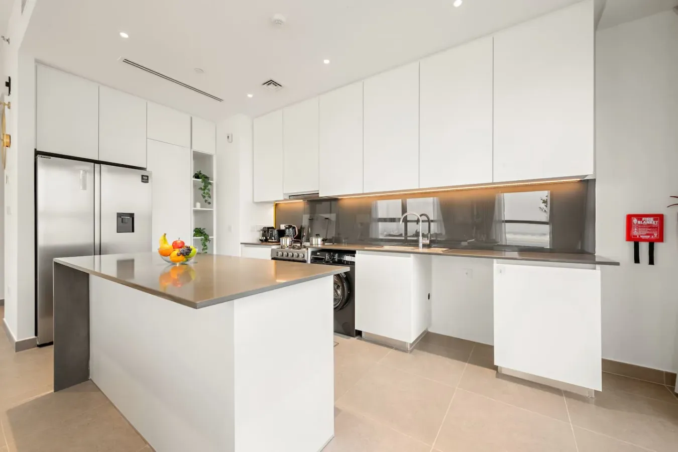 Una cocina moderna y luminosa con gabinetes blancos e isla grande.