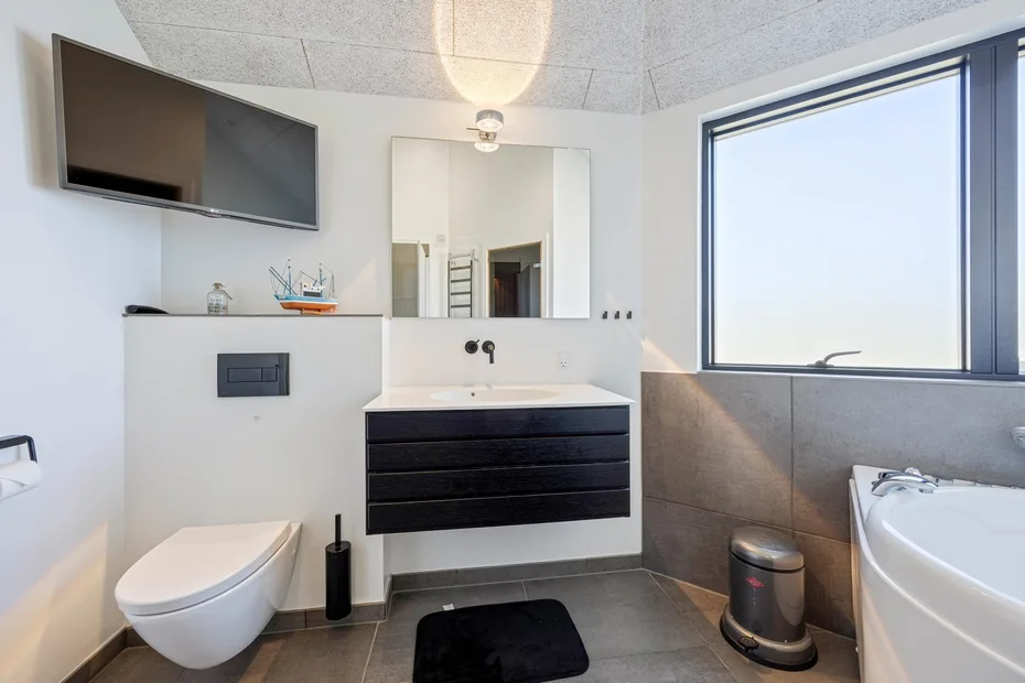 Un baño moderno con lavabo, inodoro y bañera.