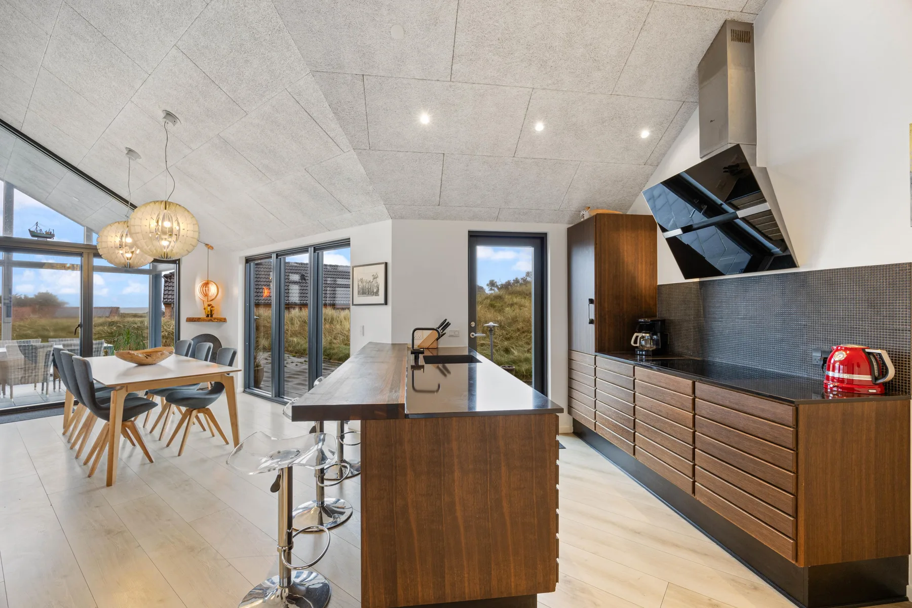 Una cocina moderna con isla y un comedor contiguo.