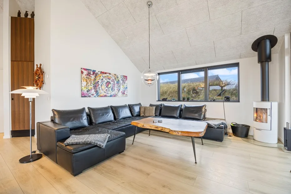 Una sala de estar con asientos seccionales y una ventana grande.