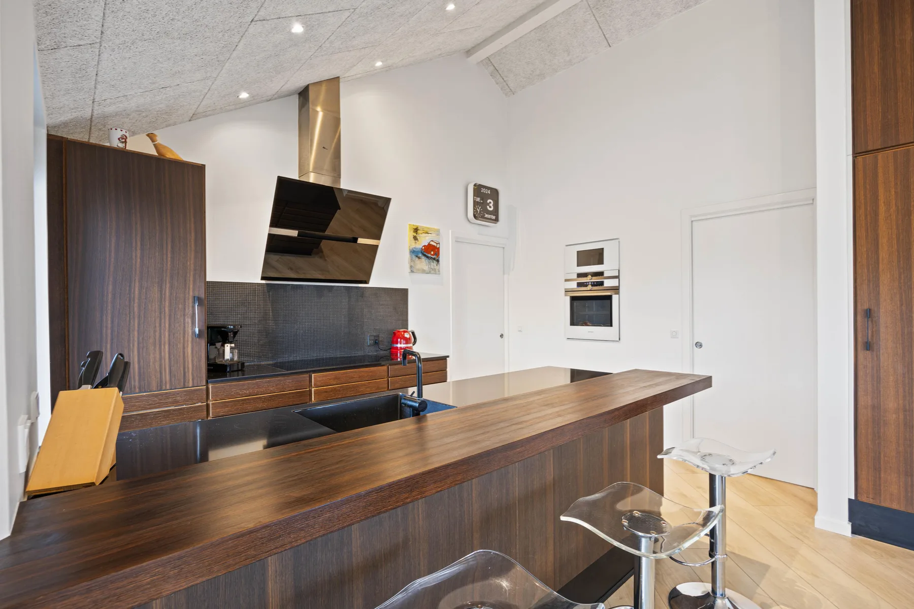 Una cocina moderna con una larga barra de madera y electrodomésticos empotrados.