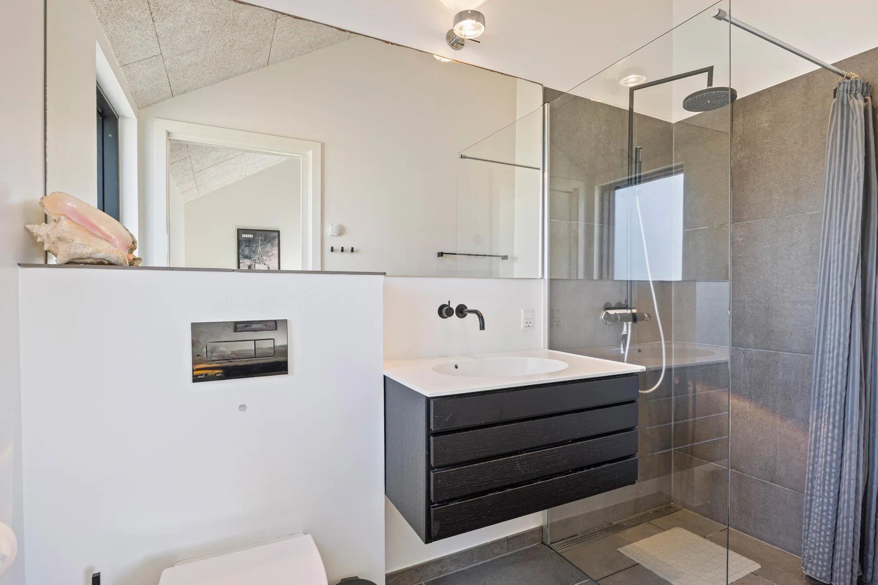 Un baño moderno con un mueble flotante y una ducha de vidrio.