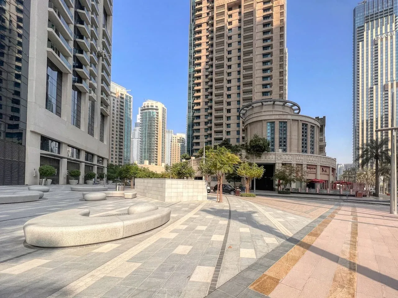 An open paved plaza sits among tall modern buildings.