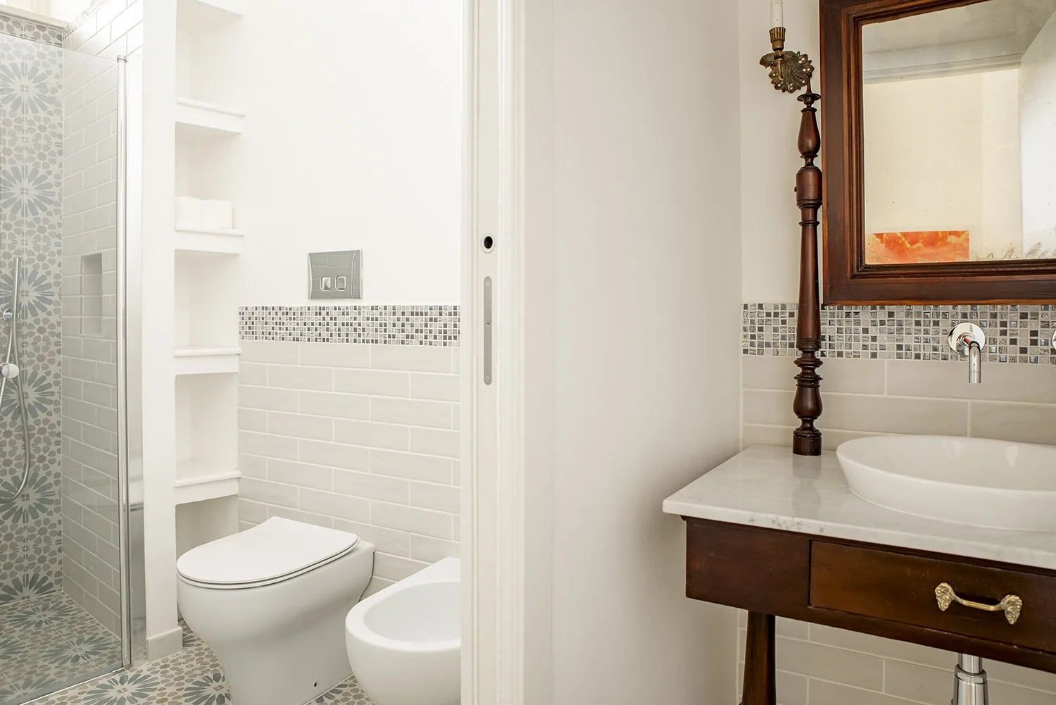 Un baño luminoso con ducha alicatada, inodoro y lavabo.