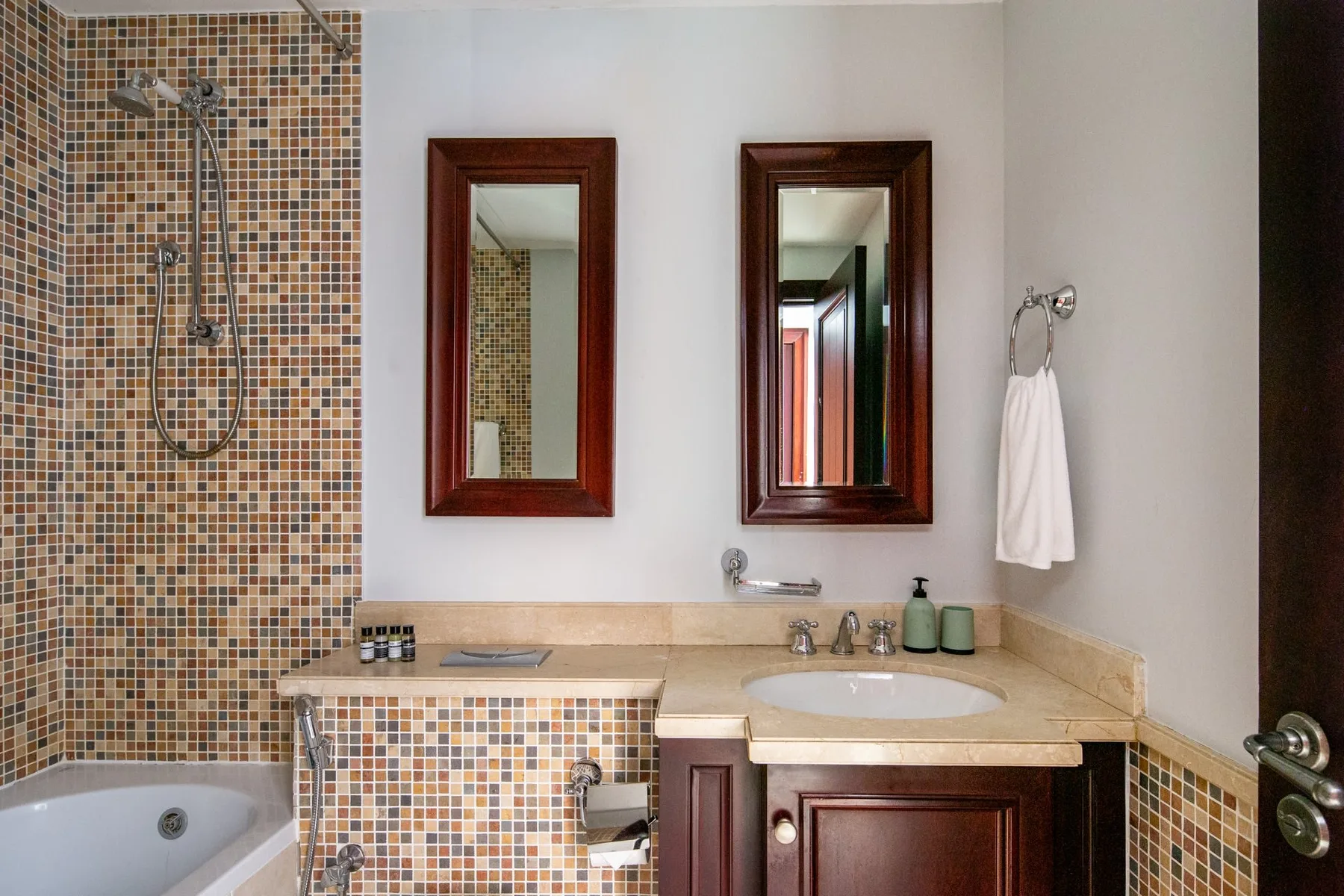 A bathroom with a tiled shower, bathtub, and sink.