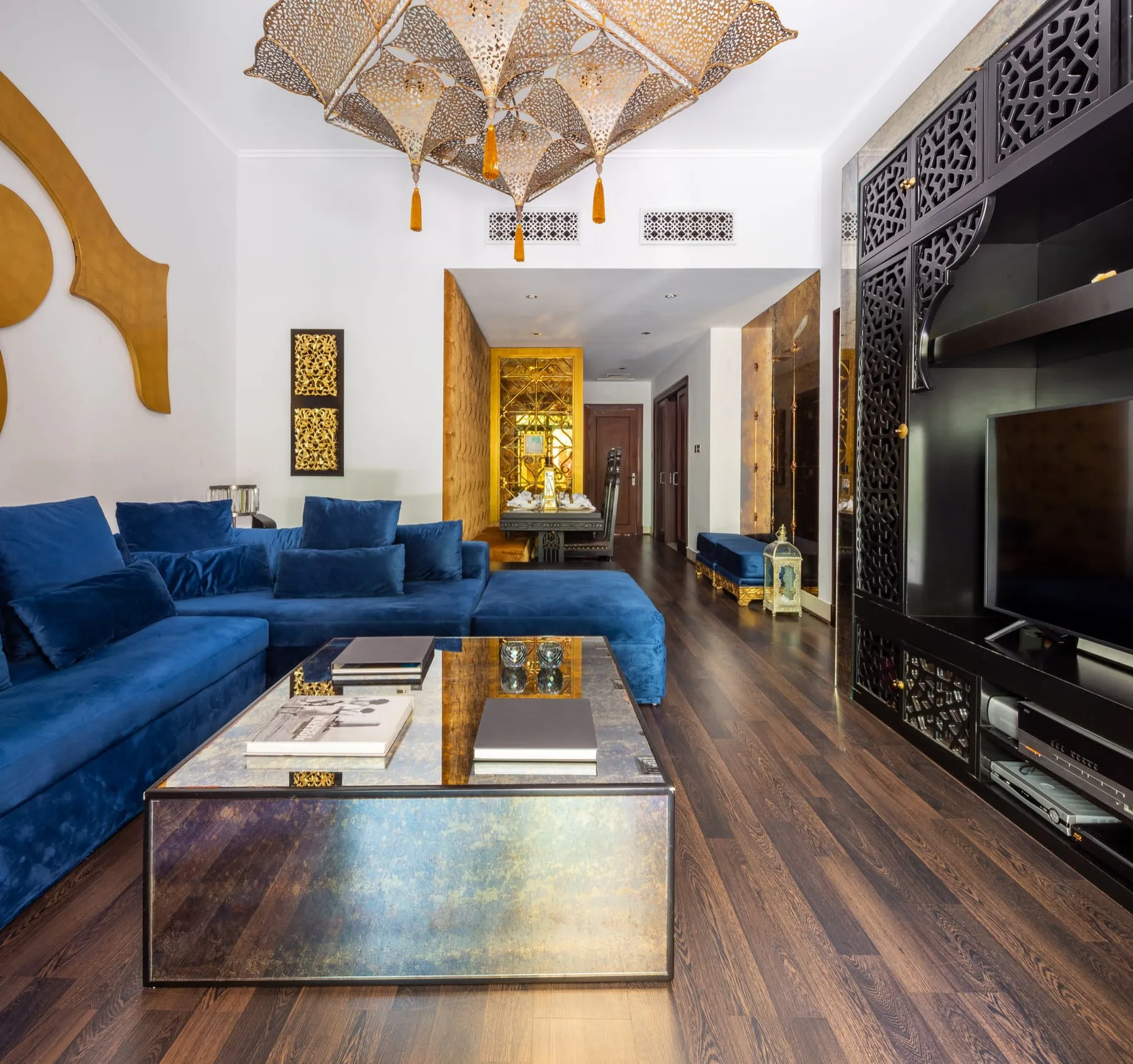A living room with blue seating and a glass-topped coffee table.