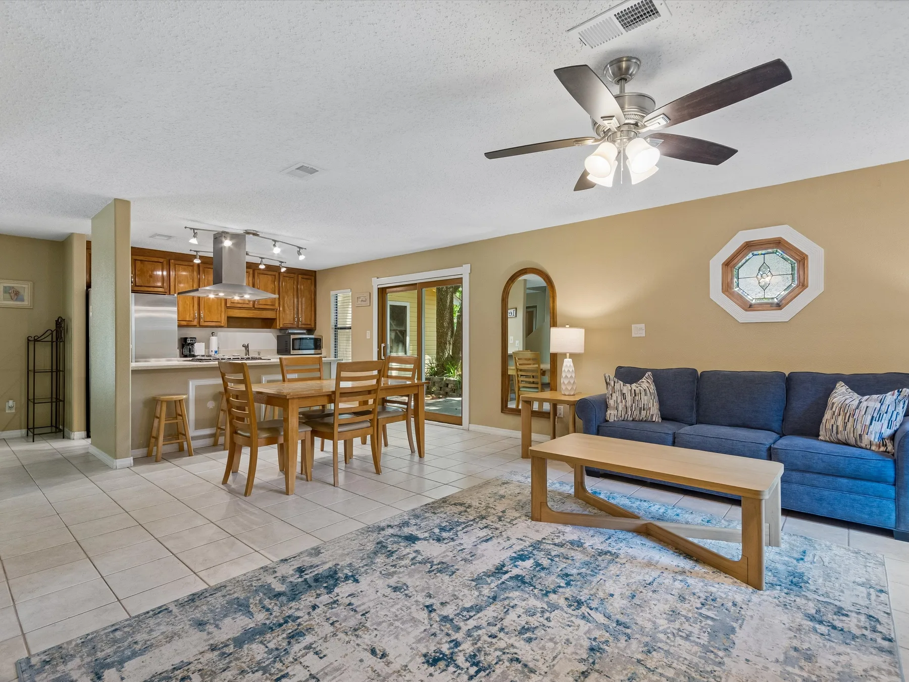 An open-plan living and dining area with a blue sofa and wooden dining table.