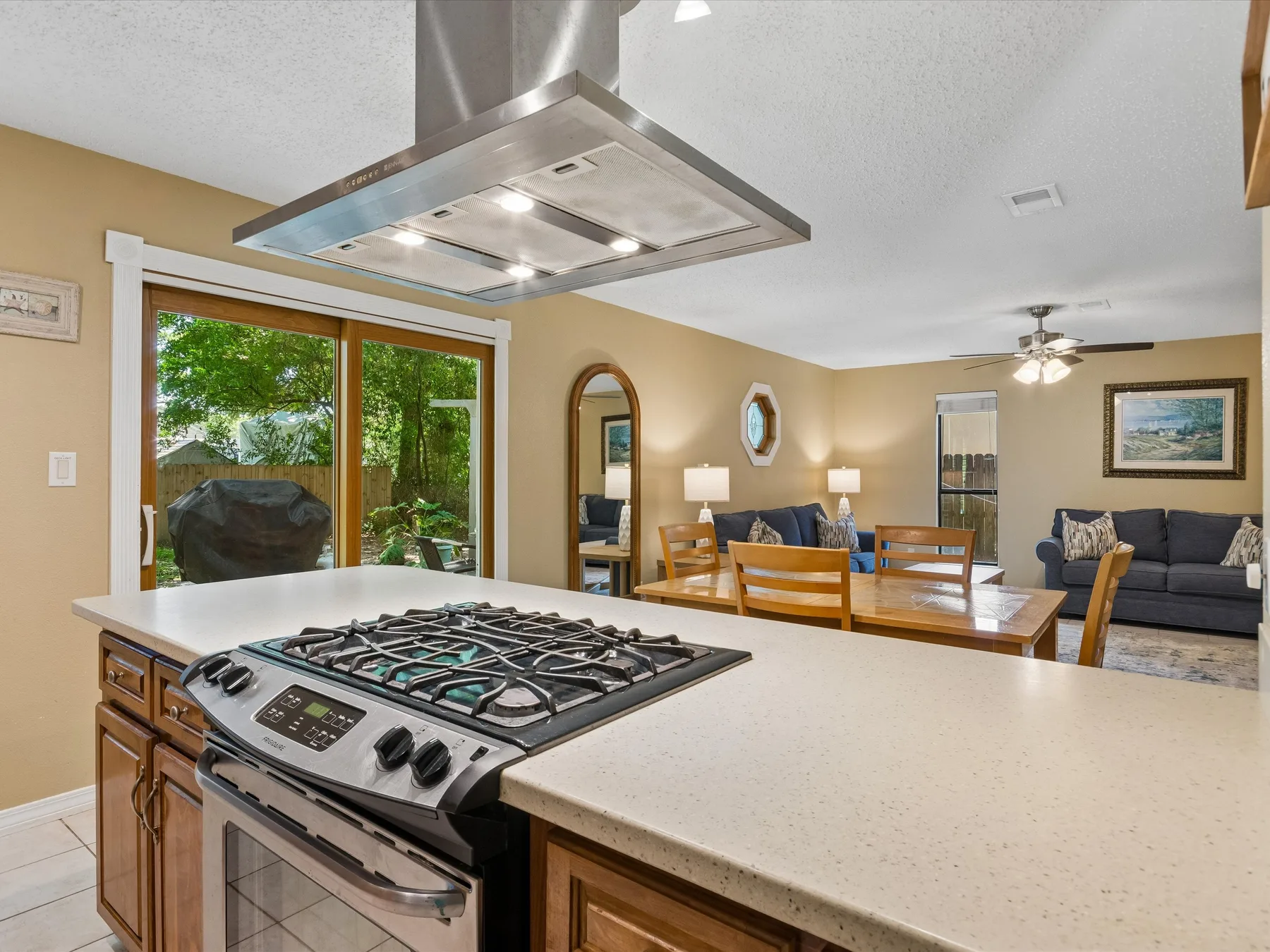 An open kitchen and living area features a central island with a cooktop.