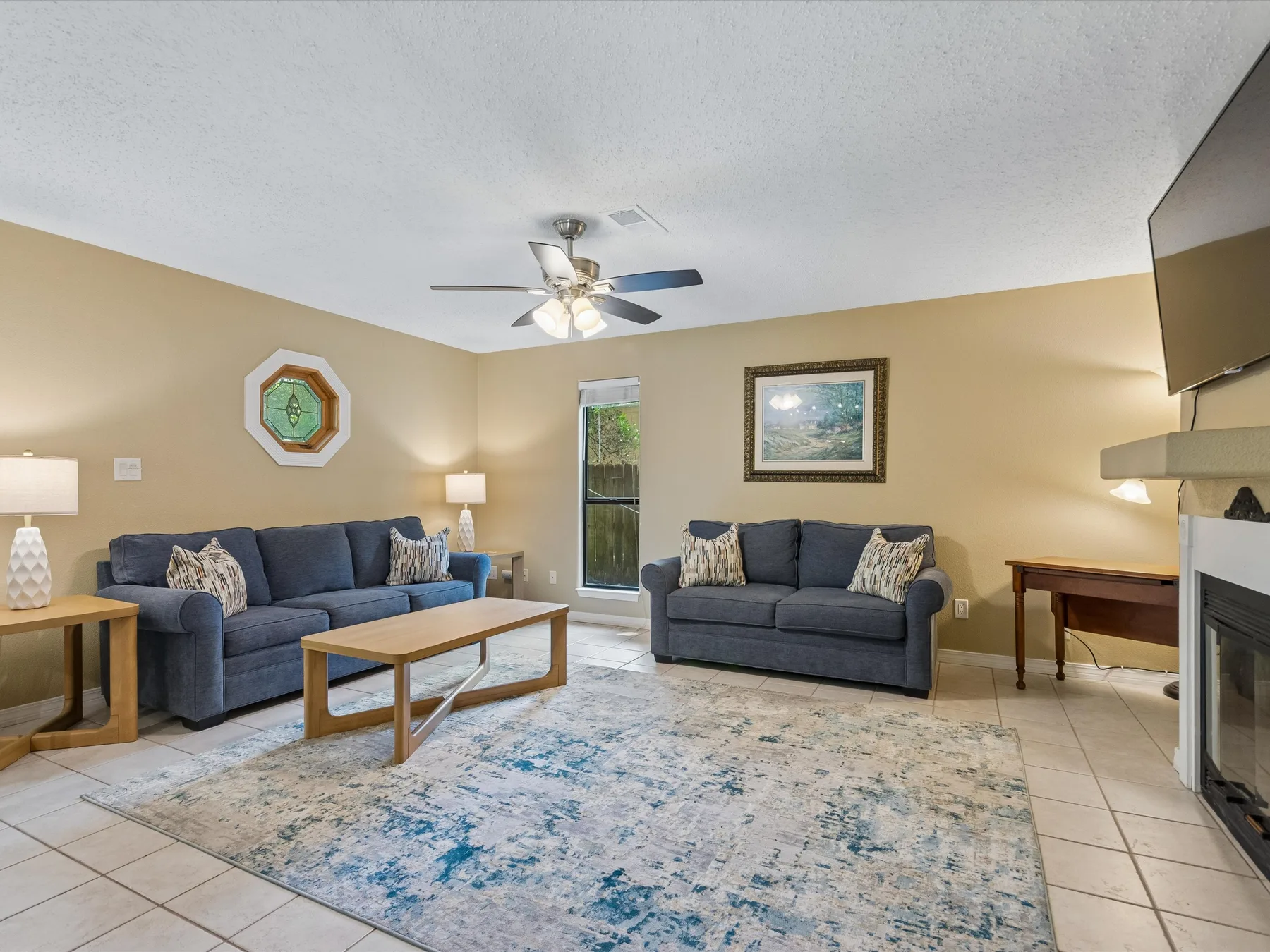A living room with seating, a coffee table, and a patterned rug.