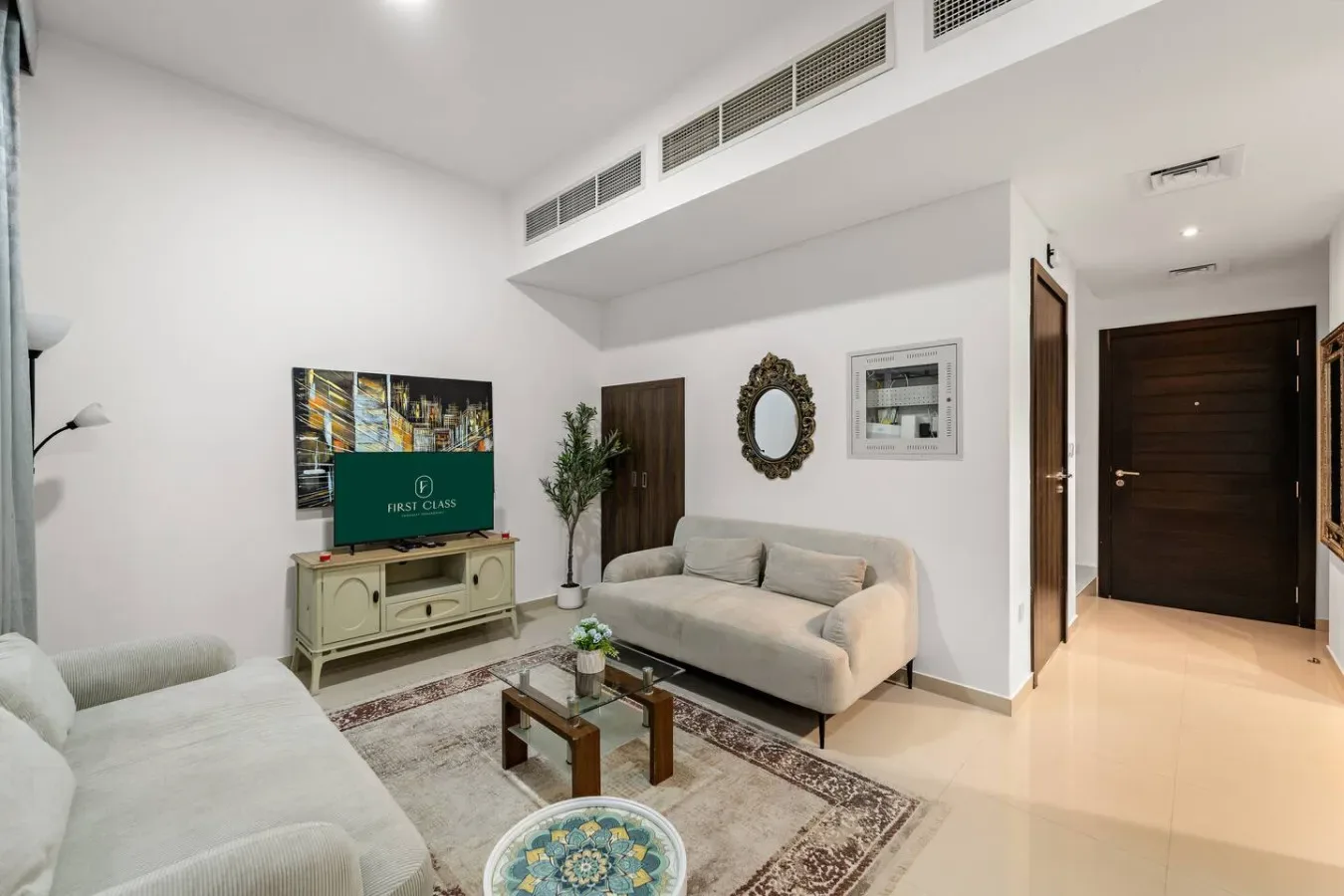 Una sala luminosa con asientos, un televisor y una pequeña mesa de centro.