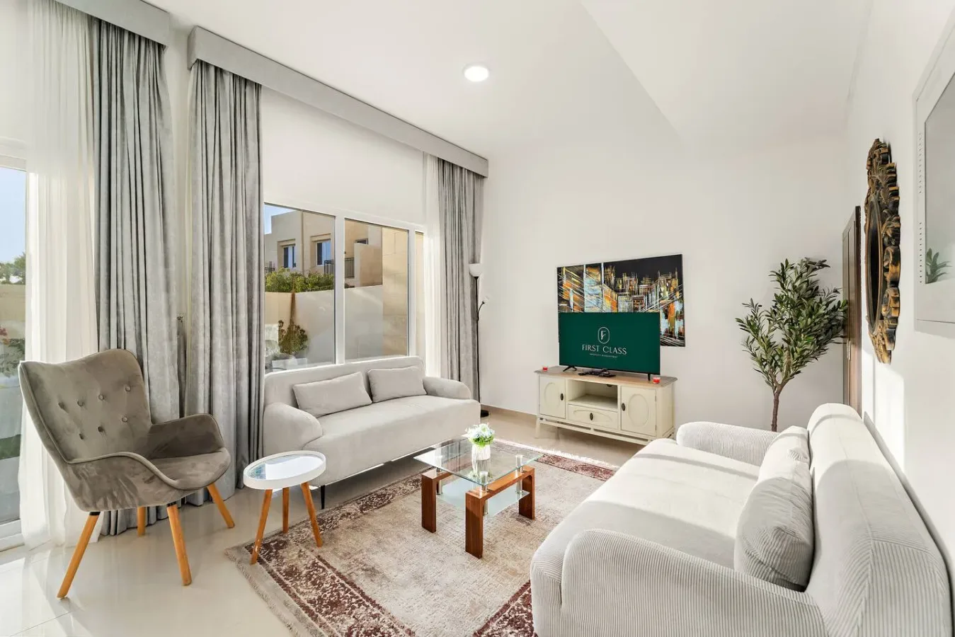 Una sala luminosa con asientos dispuestos alrededor de un televisor y una mesa de centro.
