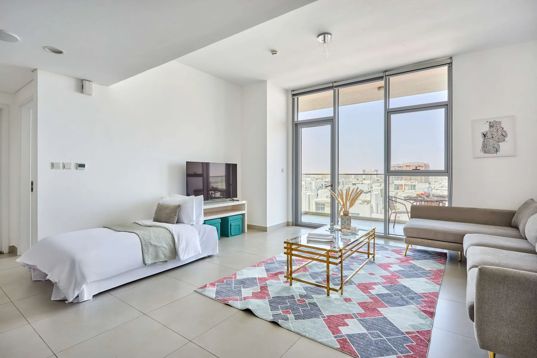 Una sala luminosa con asientos, un televisor y grandes ventanales con vistas a la ciudad.