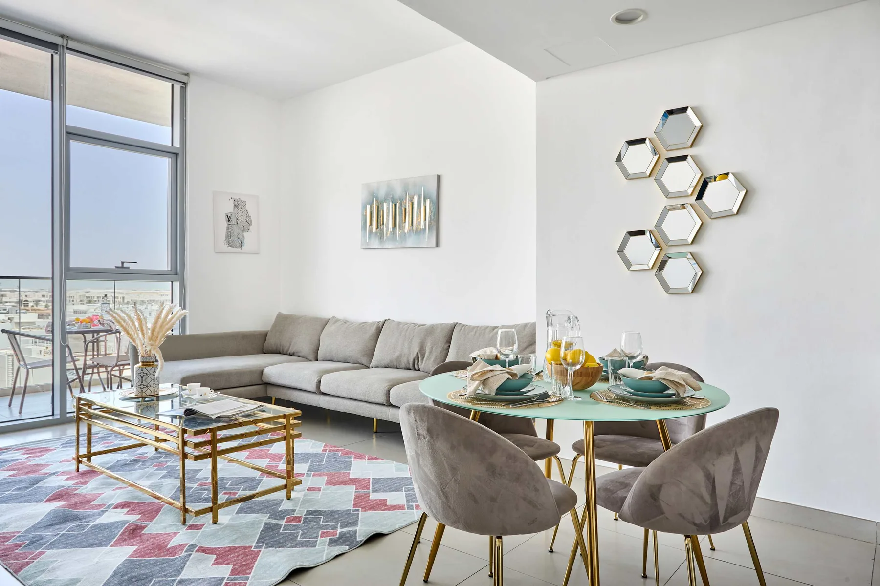 A bright living and dining area with a sectional seating area and a set dining table.